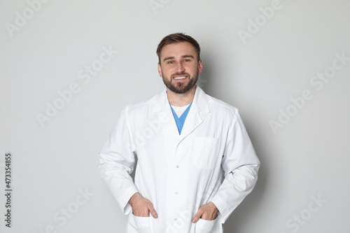 Portrait of young doctor on light grey background © New Africa