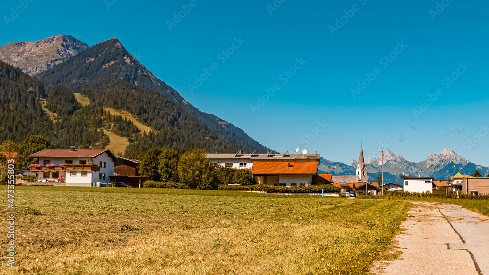 Beautiful alpine summer view with a church and the alps near Reutte in the background at Bichlbach, Tyrol, Austria