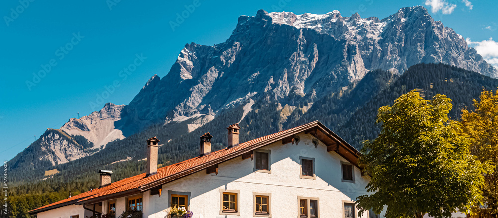 Beautiful alpine summer view with a building and the famous Zugspitze summit in the background at the Ehrwalder Alm near Ehrwald, Tyrol, Austria