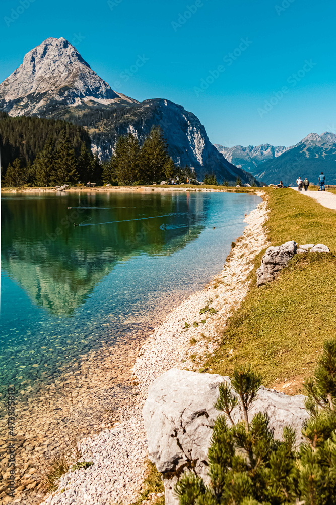Beautiful alpine summer HDR view with reflections in a lake and mountains in the background at the famous Ehrwalder Alm near Ehrwald, Tyrol, Austria