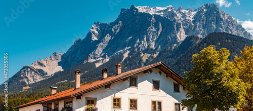 Beautiful alpine summer view with a building and the famous Zugspitze summit in the background at the Ehrwalder Alm near Ehrwald, Tyrol, Austria © Martin Erdniss