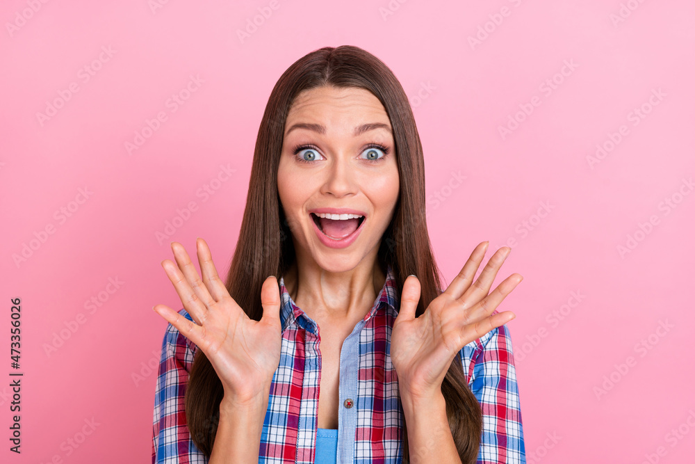 Photo of impressed brunette young lady arms up wear blue shirt isolated on pastel pink color background Photo of impressed brunette young lady arms up wear blue shirt isolated on pastel pink color background