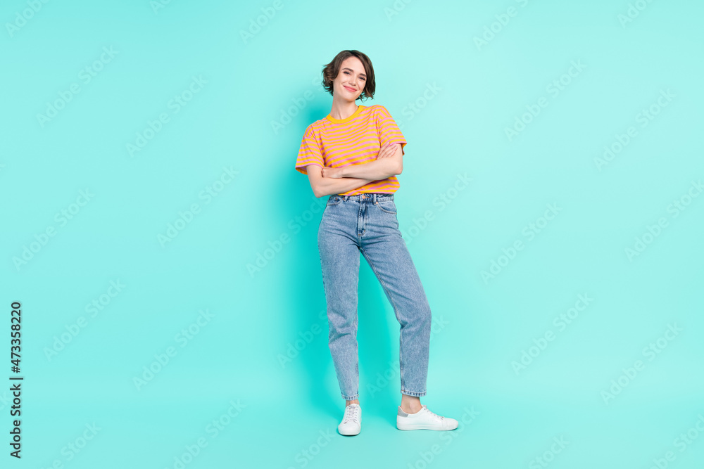 Photo of pretty charming young lady wear orange t-shirt arms folded smiling isolated turquoise color background Photo of pretty charming young lady wear orange t-shirt arms folded smiling isolated turquoise color background