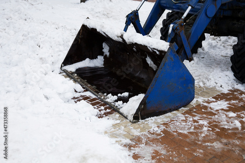 Snow removal equipment removes snow from a city street after a snowfall. © mihail39