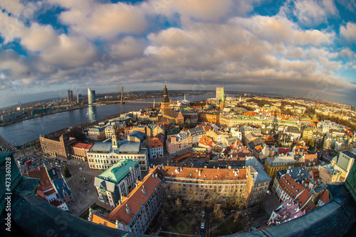 Panorama of the city of Riga on a sunny day, blue sky, morning, sunset, a view of the old town, narrow streets, red brick roofs of houses, cathedrals, a river and bridge.