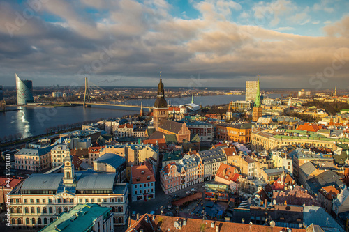 Panorama of the city of Riga on a sunny day, morning, sunset, a view of the old town, narrow streets, red brick roofs of houses, cathedrals, a river and bridge.