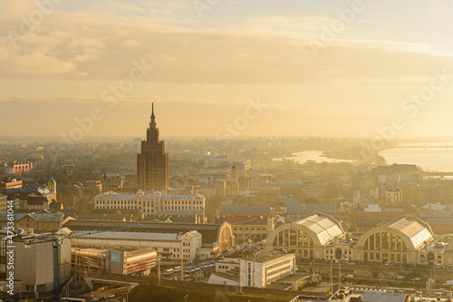 Panorama of the city of Riga on a sunny day, morning, sunset, a view of the old town, narrow streets, red brick roofs of houses, a river and bridge.