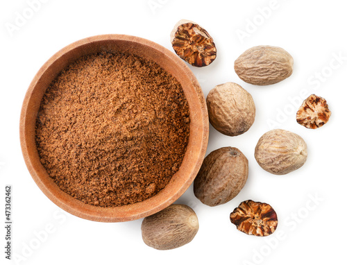 Whole and ground nutmeg in a plate on a white background, isolated. Top view photo
