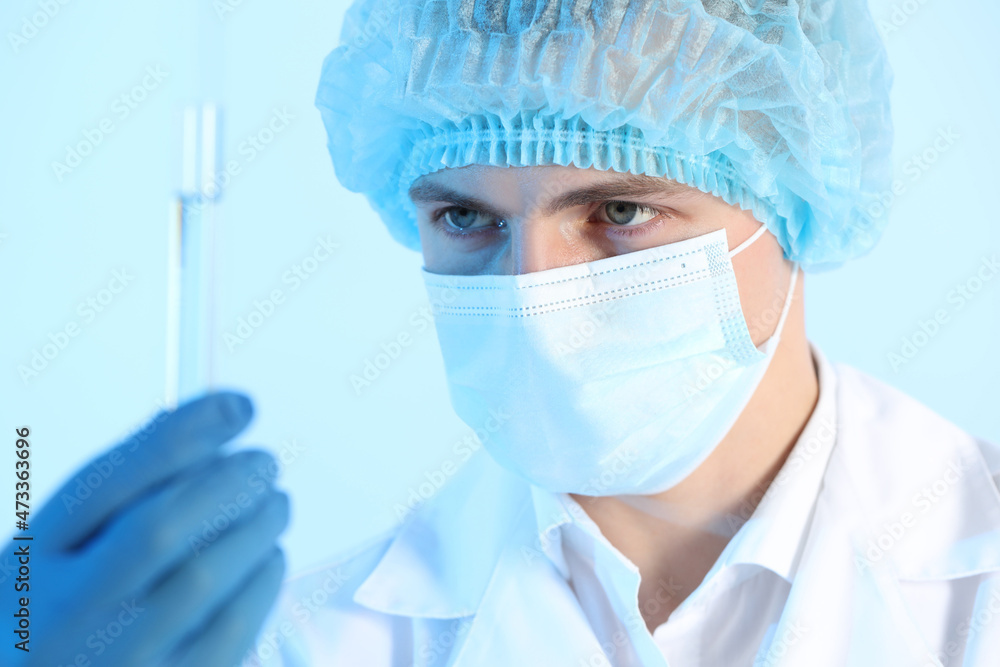 Scientist working with sample on light blue background, closeup. Medical research Scientist working with sample on light blue background, closeup. Medical research