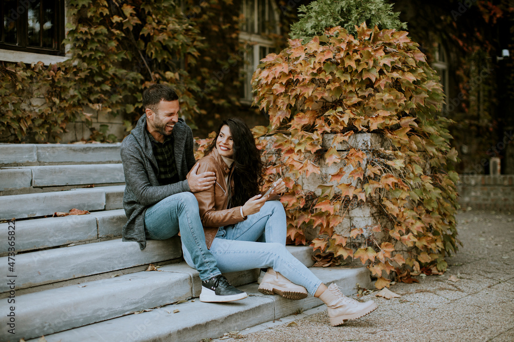 Young couple sitting on outdoor stairs on a autumn day Young couple sitting on outdoor stairs on a autumn day