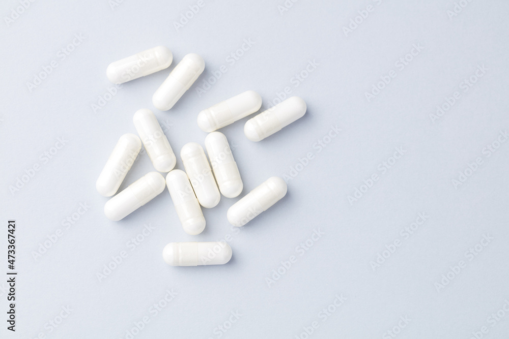 Arginine capsules. Bright paper background. Soft focus. Top view. Close up. Copy space. Arginine capsules. Bright paper background. Soft focus. Top view. Close up. Copy space.