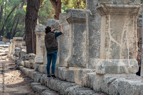 archaeologist restores an ancient inscription on a column in Phaselis, Turkey