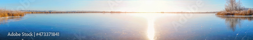 Panorama Sun over a frozen winter lake. Fabulous Winter landscape