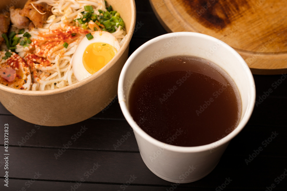 A glass of delicious beef broth, Japanese dish with wheat noodles. A platter of Chinese, Korean and Japanese cuisine A glass of delicious beef broth, Japanese dish with wheat noodles. A platter of Chinese, Korean and Japanese cuisine