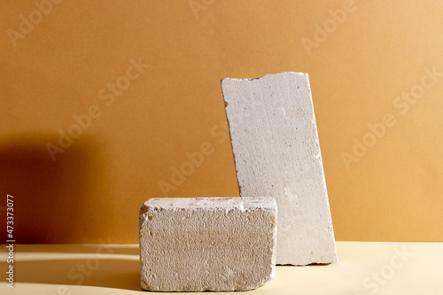 Background with geometric shapes made of concrete for cosmetic products. Rectangular podiums with shadows on a beige background. Blank mockup for product packaging presentation