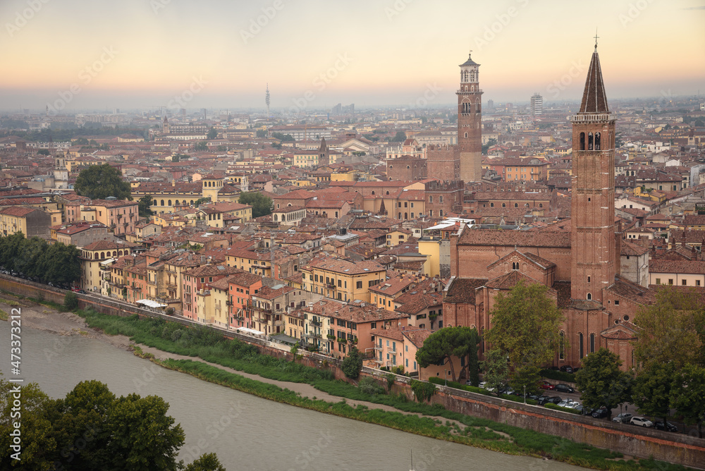 Aerial view of the beautiful city of Verona with the Bell Tower of Saint Anastasia and Laberti Tower at a cloudy sunrise, Veneto region, Italy