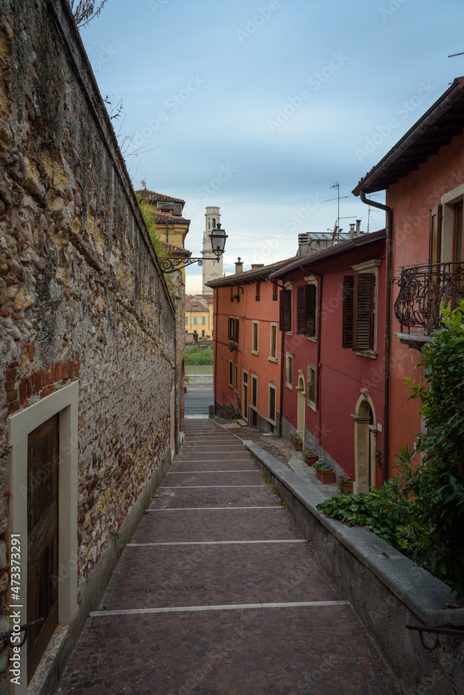 Old town street with stone staircases going down to Stone Bridge (Ponte di Pietra), Verona, Veneto region, Italy