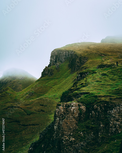 man hiking in distance with clouds