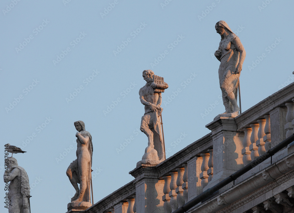 Statues of the Marciana library's building in front of the full Moon, Venice, Veneto, Italy