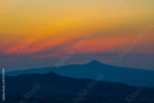 Mountain Peak. Mountain peak and silhouettes at sunset with dramatic clouds © senerdagasan