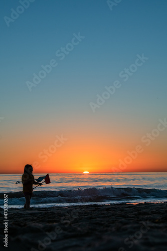 silhouette of a person on a beach at sunset © Mike