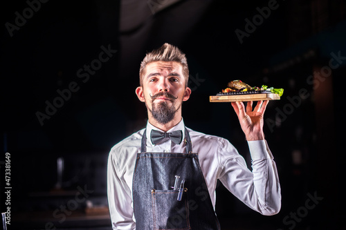 Professional friendly flunky helpfully serves salad at a festive event. photo