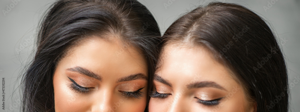 Portrait of young beautiful two women with long lashes and closed eyes after eyelash extensions Portrait of young beautiful two women with long lashes and closed eyes after eyelash extensions