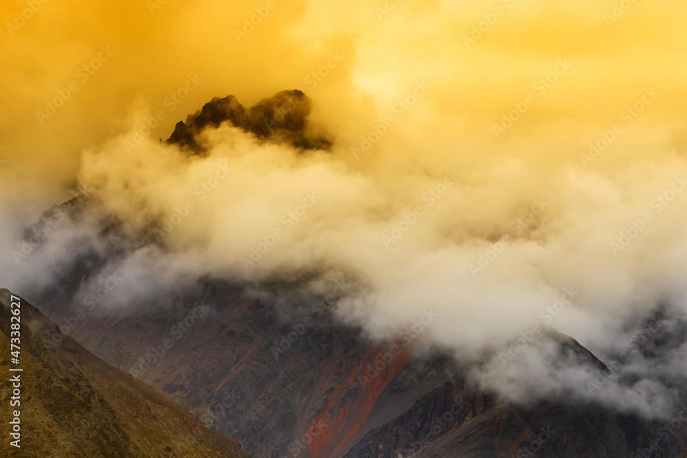 Orange clouds embracing a mountain peak over highway of Zojila Pass, a high mountain pass between Srinagar and Leh at 11575 ft, 9 Km stretch. Highest Indian National Highway.