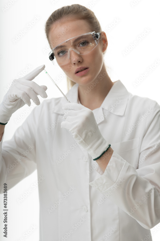 The girl laboratory assistant shows an indicator tube with the result of the analysis. Laboratory assistant in a medical laboratory or a petroleum product quality laboratory The girl laboratory assistant shows an indicator tube with the result of the analysis. Laboratory assistant in a medical laboratory or a petroleum product quality laboratory