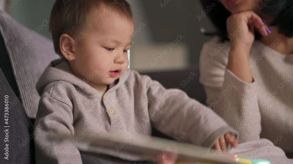 Happy Asian boy playing with book at home Happy Asian boy playing with book at home