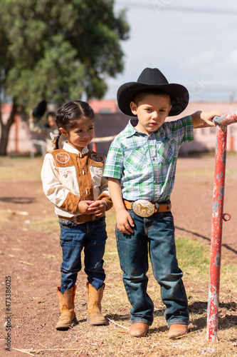 Two children in cowboy clothes in a ranch