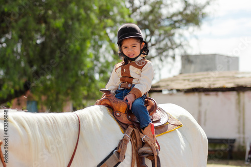 Cute cowgirl riding a horse in a ranch