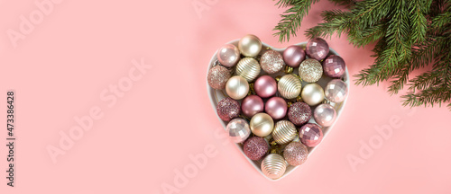Pink background with fir tree and Christmas toys for Christmas design. Merry christmas and Happy Holidays. Banner. Flat lay, top view and place for text. photo