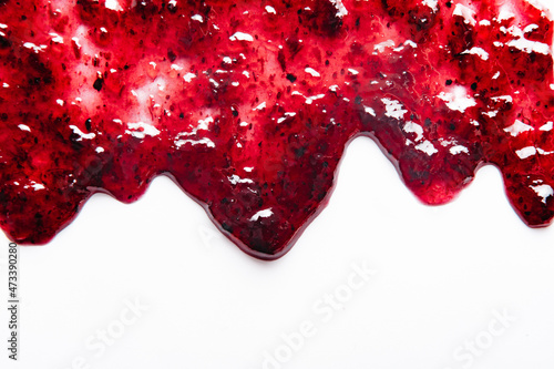 Sweet red jam spil isolated on white background. Abstract food background wiith copy space. Flat lay