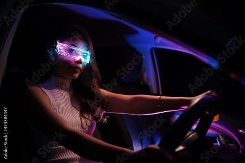 Fashion cyberpunk girl drive a supercar. Asian woman  with future digital glasses,future technology concept
