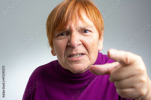 Senior beautiful woman standing over isolated grey background pointing displeased and frustrated to the camera  angry and furious with you