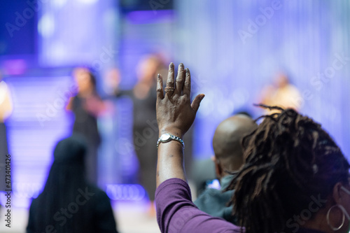 African American Woman in a Red Dress with Her Hand Raised in Church