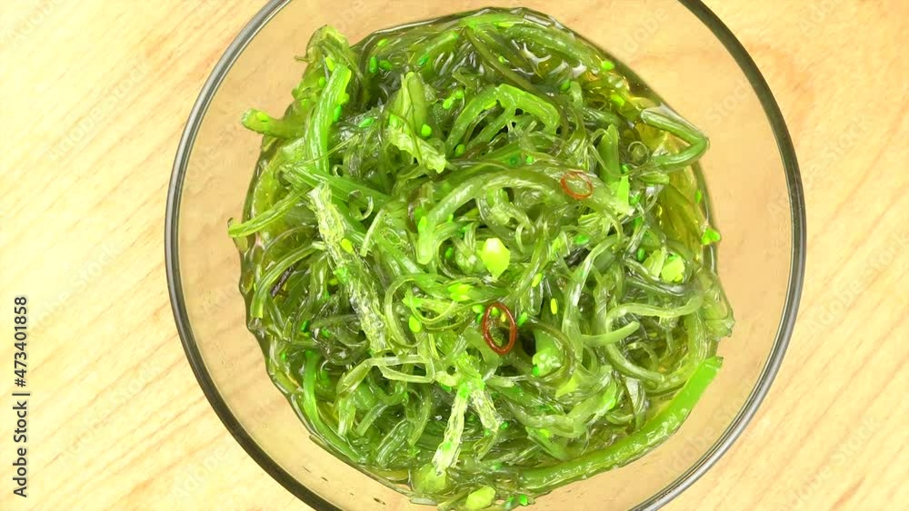 Chuka seaweed in a glass bowl on a wooden stand. Close-up from above. Rotation. Chuka seaweed in a glass bowl on a wooden stand. Close-up from above. Rotation.