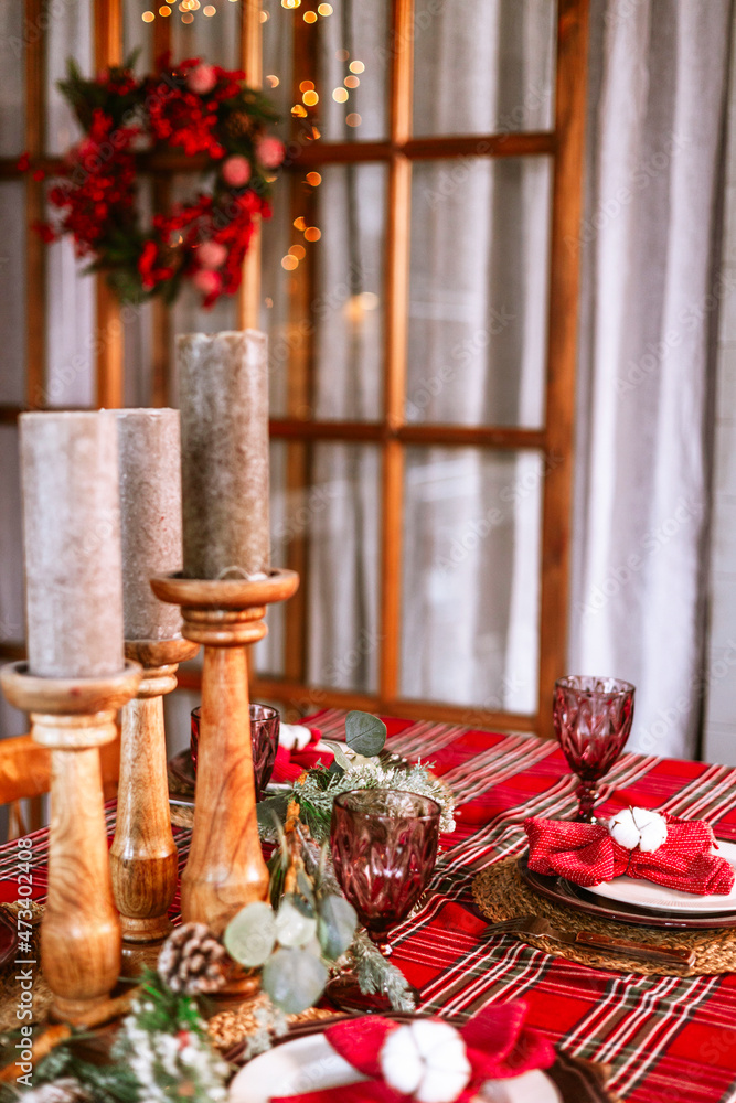 Christmas set table in living room chalet ready for festive Christmas or New Year's festive dinner, red refrigerator, Christmas wreath