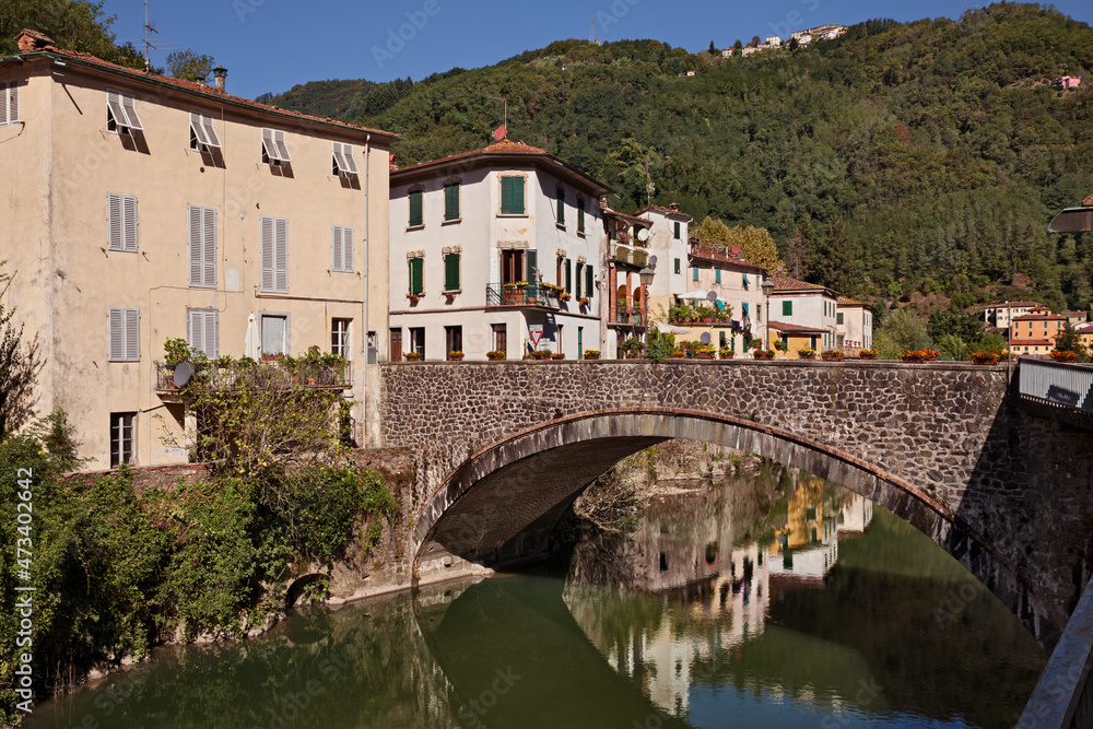 Bagni di Lucca, Tuscany, Italy: landscape of the village known for its thermal springs with the ancient bridge, buildings and the Apennine mountain in the background