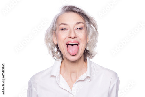 Shot of a beautiful mature woman having fun and teasing sticking out her tongue isolated on white background