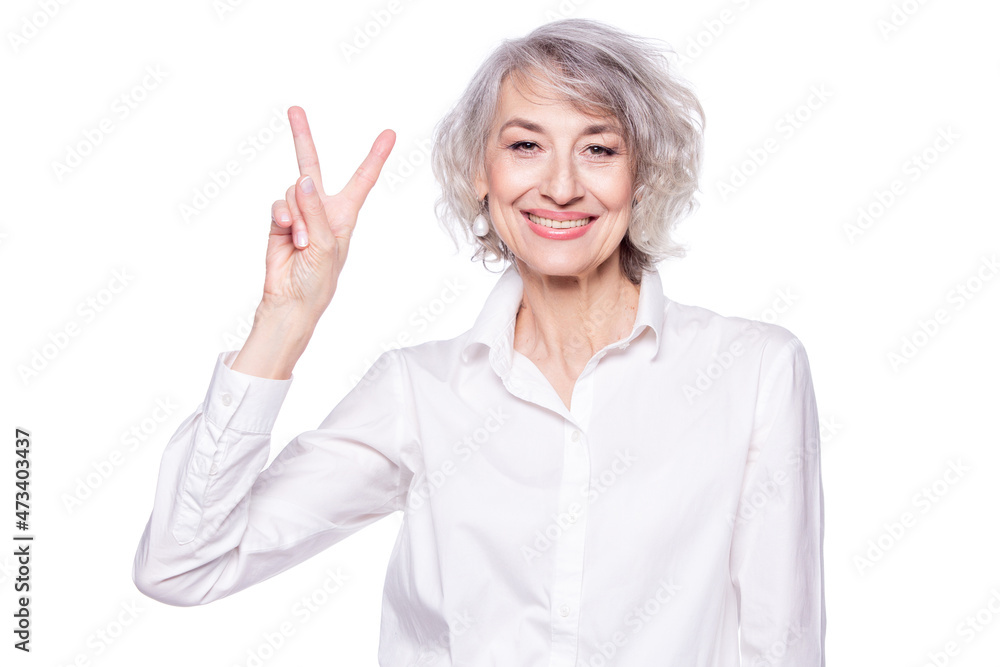 Close up portrait of senior grey-haired woman wearing elegant shirt standing over isolated white background smiling with happy face doing victory sign Close up portrait of senior grey-haired woman wearing elegant shirt standing over isolated white background smiling with happy face doing victory sign