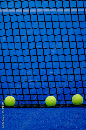Three balls an the net of a paddle tennis court © Vic