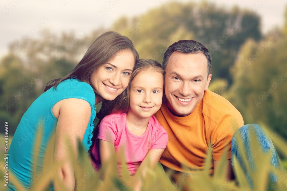 happy family with children having good time sitting on the grass in city park happy family with children having good time sitting on the grass in city park