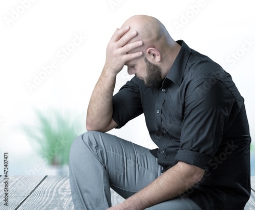 Depressed man losing job and heartbroken at same time sitting alone. Mental health and depression concept. © BillionPhotos.com