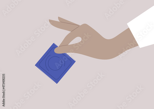 Sexual education, an isolated hand holding a condom
