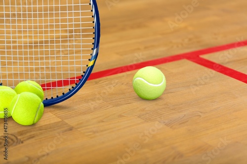 Tennis ball, line and racket on a court floor
