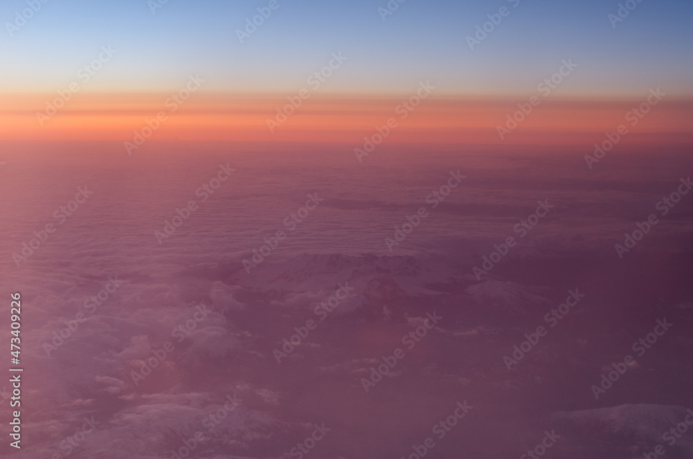 Obraz premium Early sunrise above clouds. Airplane view