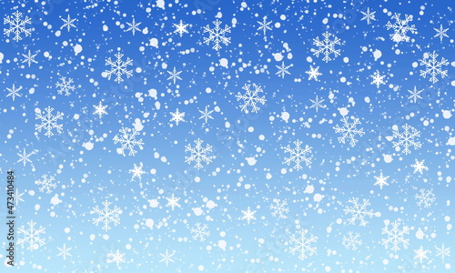Snow and snowflakes fall over a graded blue background