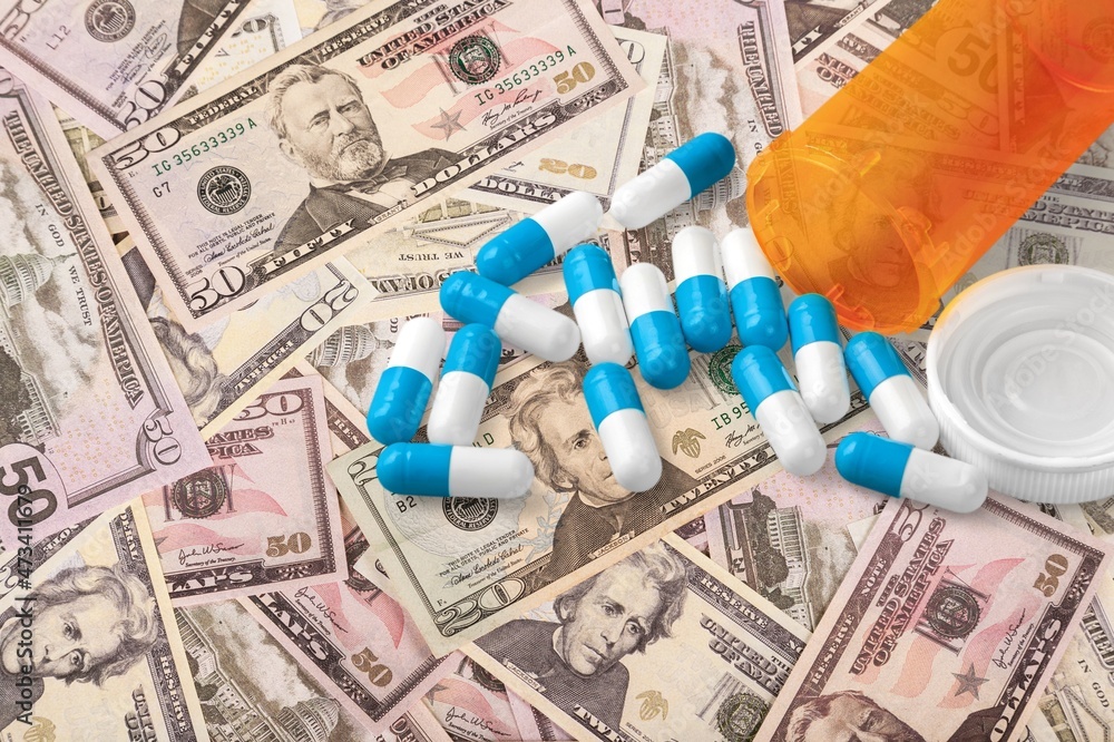 US dollars and oral drug against Covid-19. Concept of purchasing, buying or roll out tablets US dollars and oral drug against Covid-19. Concept of purchasing, buying or roll out tablets